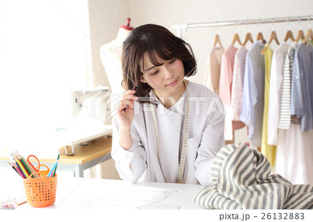 生地を見ながらデザインを考えるファッションデザイナー 26132883