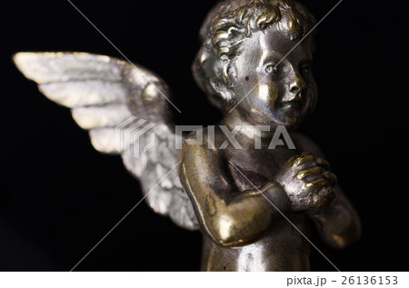 Praying brass angel side view over black Praying brass angel side view over black 26136153