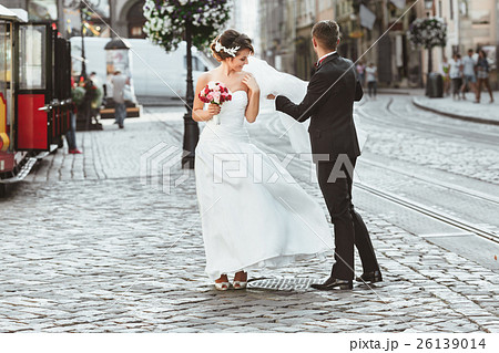 Bride and bridegroom walking in the city 26139014