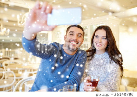 couple taking smartphone selfie at cafe restaurant 26140796