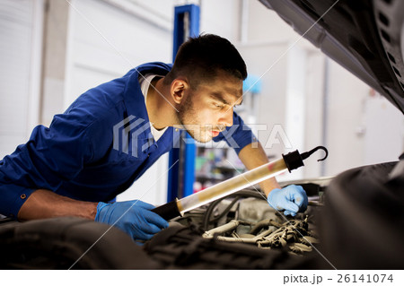 mechanic man with lamp repairing car at workshop mechanic man with lamp repairing car at workshop 26141074