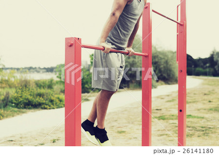 young man exercising on horizontal bar outdoors young man exercising on horizontal bar outdoors 26141180
