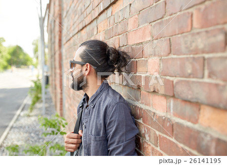 man with backpack standing at city street wall man with backpack standing at city street wall 26141195
