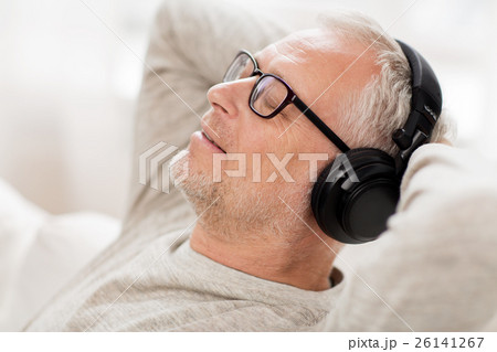 happy man in headphones listening to music at home happy man in headphones listening to music at home 26141267