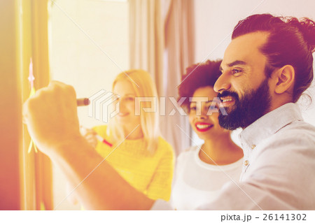 happy creative team writing on stickers at office happy creative team writing on stickers at office 26141302