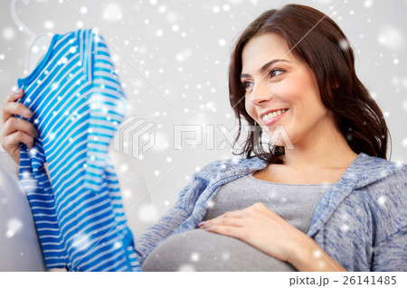 happy woman holding baby boys bodysuit at home 26141485