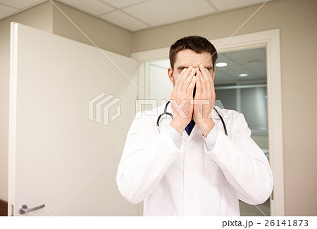sad or crying male doctor at hospital ward 26141873