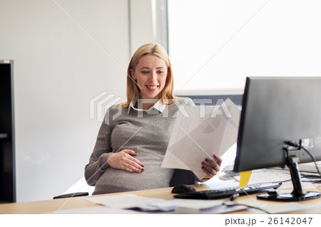 pregnant businesswoman reading papers at office pregnant businesswoman reading papers at office 26142047