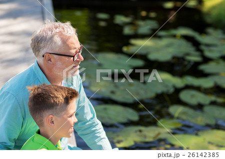 grandfather and grandson sitting on river berth grandfather and grandson sitting on river berth 26142385