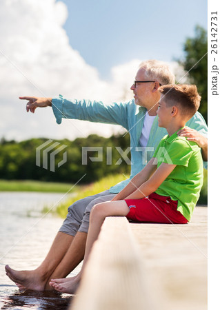 grandfather and grandson sitting on river berth grandfather and grandson sitting on river berth 26142731
