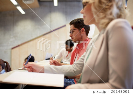 group of students with notebooks in lecture hall group of students with notebooks in lecture hall 26143001