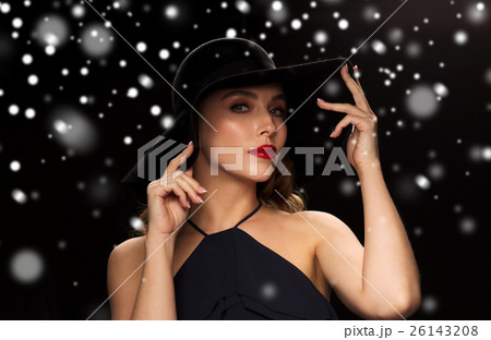 beautiful woman in black hat over snow 26143208