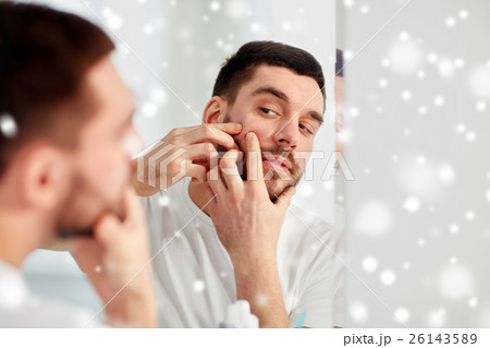 man squeezing pimple at bathroom mirror man squeezing pimple at bathroom mirror 26143589