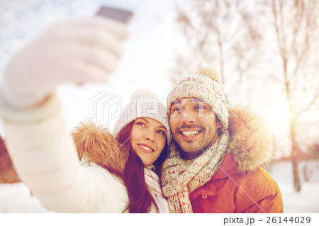 happy couple taking selfie by smartphone in winter happy couple taking selfie by smartphone in winter 26144029