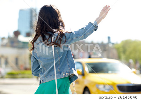 young woman or girl catching taxi on city street young woman or girl catching taxi on city street 26145040