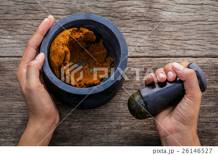 The women hold pestle with mortar . 26146527