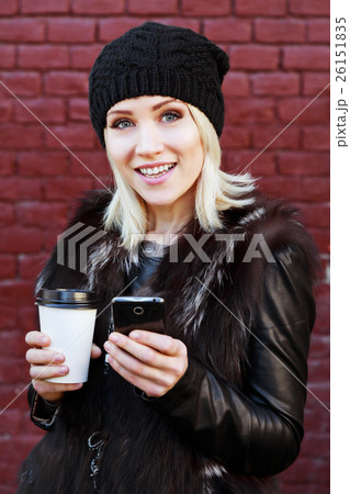 Cute girl with cup of coffee and mobile phone 26151835