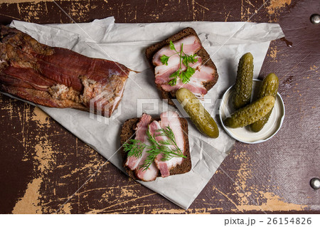 Slices of smoked bacon with rye bread and pickles Slices of smoked bacon with rye bread and pickles 26154826