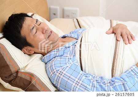 ベッドで寝るパジャマの男性 26157605