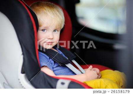 Pretty toddler boy sitting in car seat 26158179