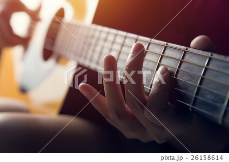Female hand playing on acoustic guitar 26158614