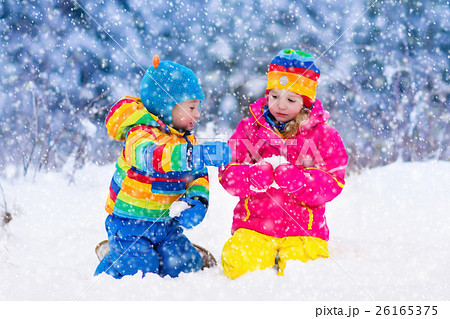 Children playing in snowy winter park 26165375
