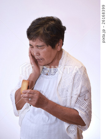 お菓子を食べるのを躊躇する60代女性 お菓子を食べるのを躊躇する60代女性 26168399