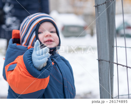 Attractive baby boy playing with the first snow Attractive baby boy playing with the first snow 26174895