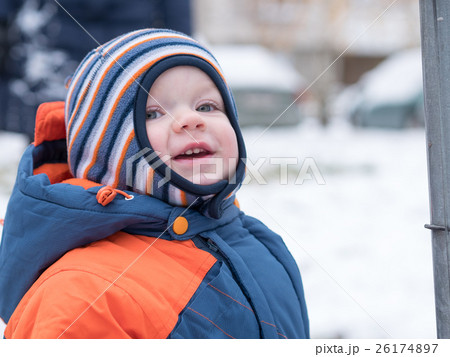 Attractive baby boy playing with the first snow Attractive baby boy playing with the first snow 26174897