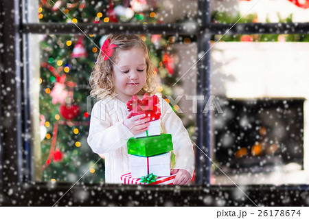 Little girl opening presents on Christmas morning Little girl opening presents on Christmas morning 26178674