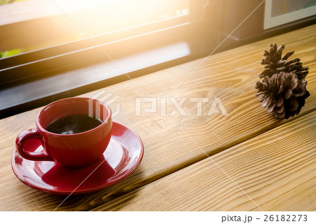 Coffee in red cup on wooden plank in morning. Coffee in red cup on wooden plank in morning. 26182273