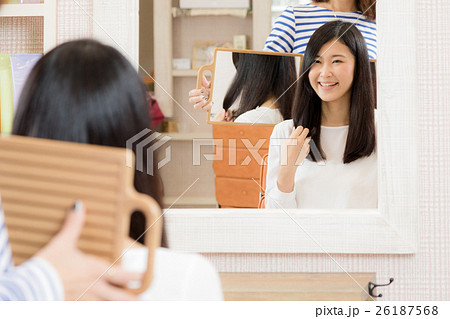 美容院で髪を切る女性 ヘアサロン 鏡 仕上がりの写真素材