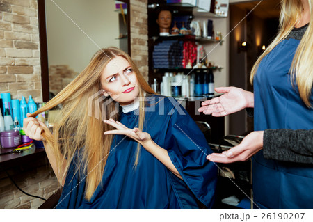 Beautiful girl showing her hair to hairdresser. 26190207