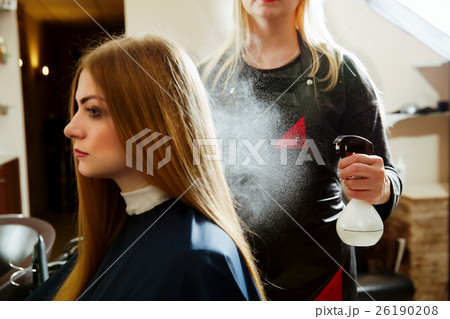 Woman hairdresser uses spray for hair 26190208