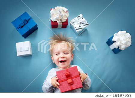 Smiling baby on red blanket with presents Smiling baby on red blanket with presents 26197958