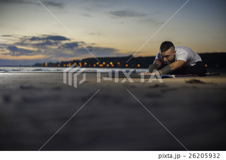Attractive man doing yoga exercises on the beach Attractive man doing yoga exercises on the beach 26205932
