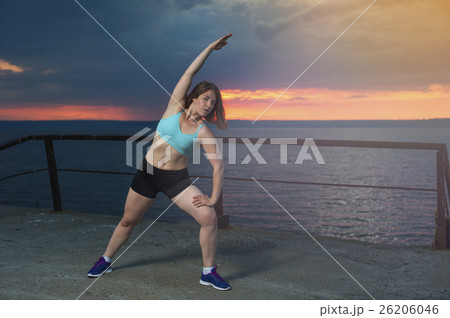 Young woman warming up on the pier 26206046