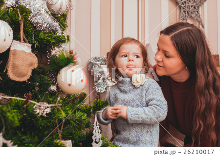 Mom and daughter decorating Christmas tree 26210017