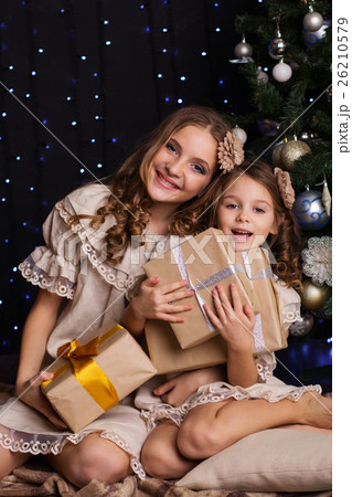Two girls friends with gifts near christmas tree 26210579