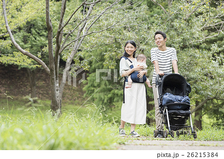 公園で散歩する赤ちゃんと両親 公園で散歩する赤ちゃんと両親 26215384