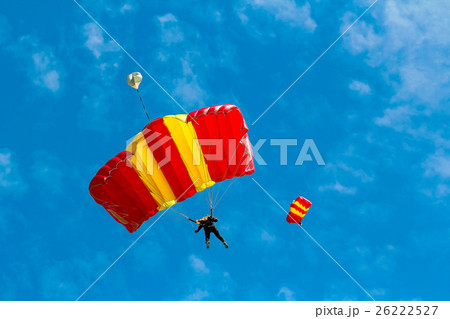 Skydiver and colorful parachute on blue sky Skydiver and colorful parachute on blue sky 26222527
