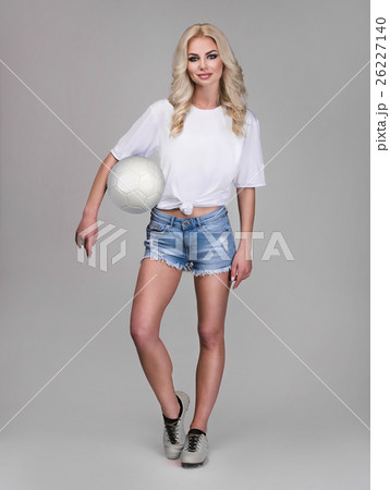 young woman holding soccer ball on her hand 26227140