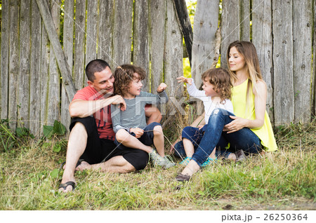 Beautiful young family against old wooden fence 26250364