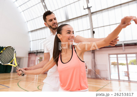 Professional tennis instructor showing woman how 26253817