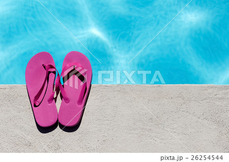 Pink slippers near swimming pool 26254544