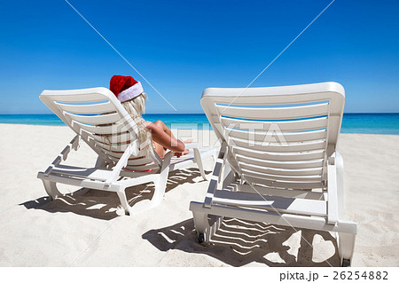 Happy woman in Santa Helper Hat lie on sunbed 26254882