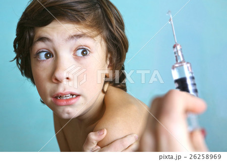 syringe with injection vaccination. Boy is afraid. 26258969