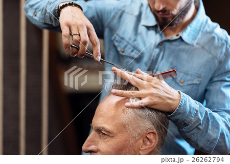 Closeup of senior man having haircut in barbershop Closeup of senior man having haircut in barbershop 26262794