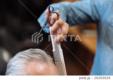 Close up of barber combing senior client hair Close up of barber combing senior client hair 26263029