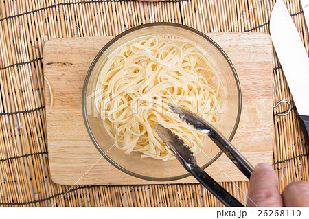 cooking oil to Spaghetti with tongs 26268110